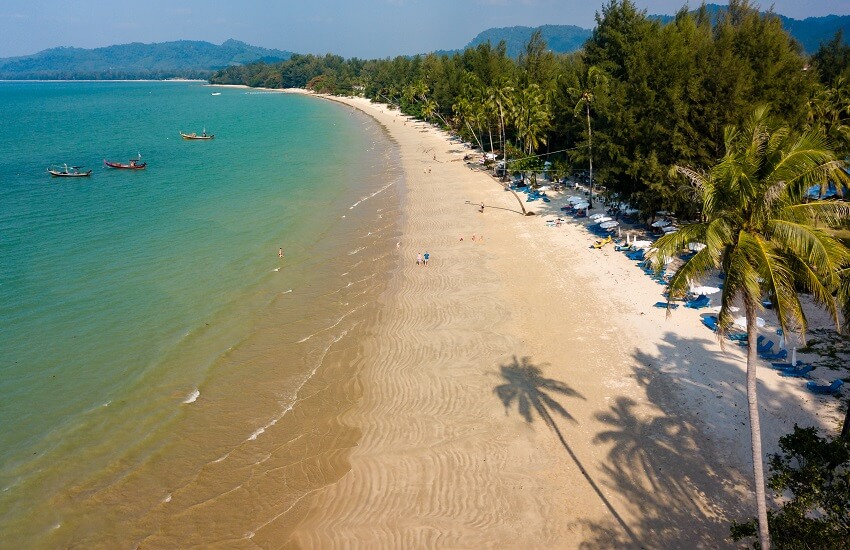 Coconut Beach in Khao Lak Thailand with fishing boats and walkers
